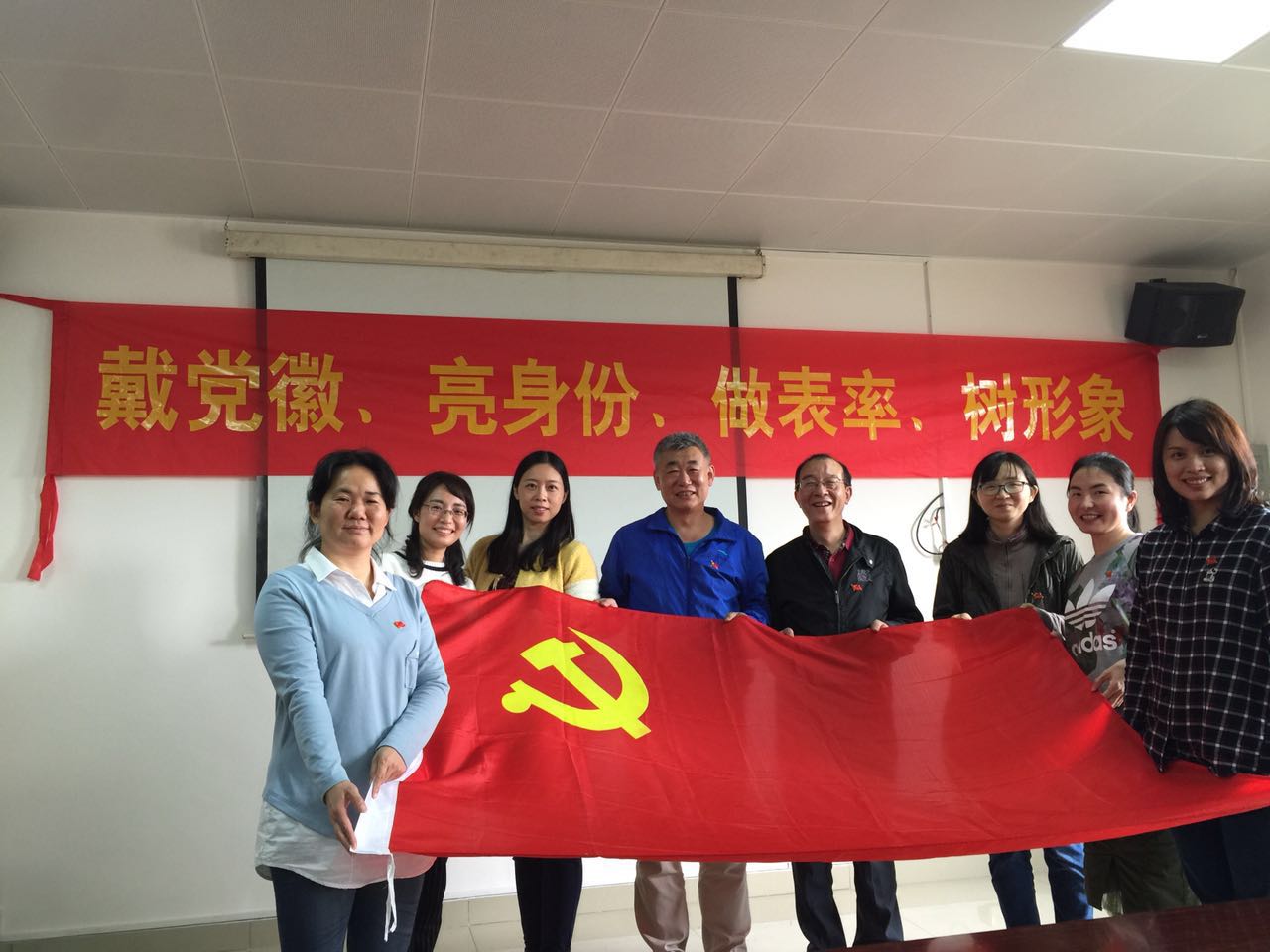 公共基础课部(思想政治理论课教学部)联合党支部老党员带领新党员佩戴党徽上岗